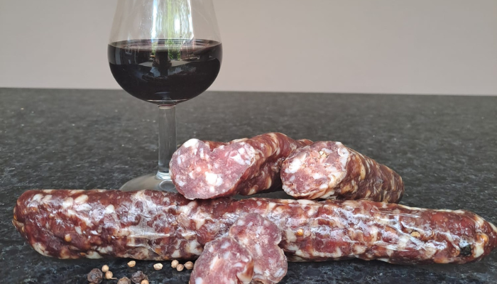 Droge worst met rode port en kruiden, gesneden in dunne plakjes op een houten plank