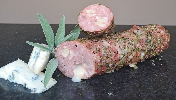 Grilworst met gorgonzola, in plakjes gesneden en gepresenteerd op een houten plank